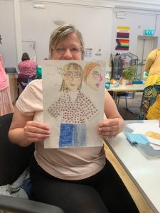 Sara holding a drawing of her puppet.